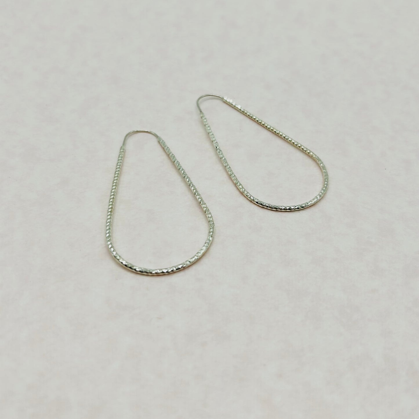Aretes de Tubo Facetado en Forma de Gota de Plata
