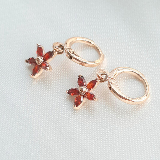 Aretes Huggies con Colgantes de Flor con Zirconias Rojas de Oro Laminado